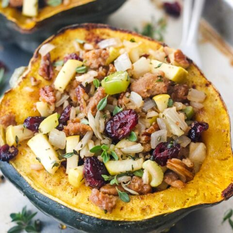 Close up of stuffed roasted squash with dried cranberries, pecans, and herbs.