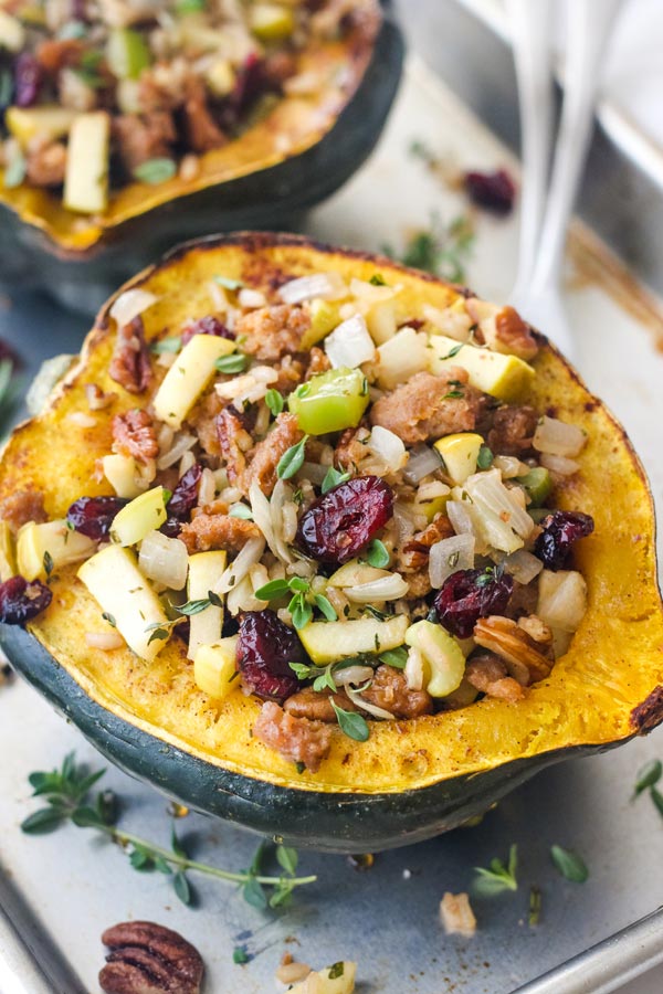 Close up of stuffed roasted squash with dried cranberries, pecans, and herbs.