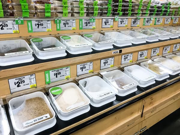 Row of bulk bins full of grains and flours.