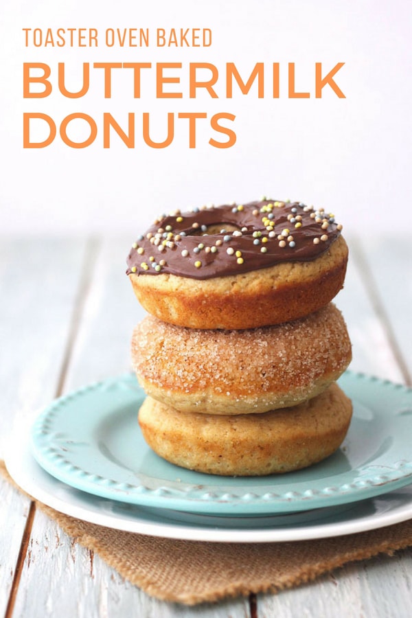 Three baked donuts stacked on a blue plate.