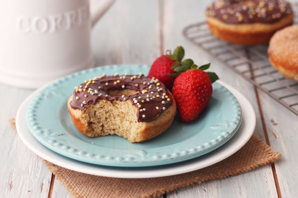 A donut topped with chocolate and sprinkles with a bite taken out of it.