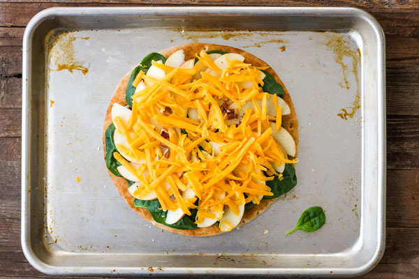 Topped pizza on a quarter sheet pan ready for baking.