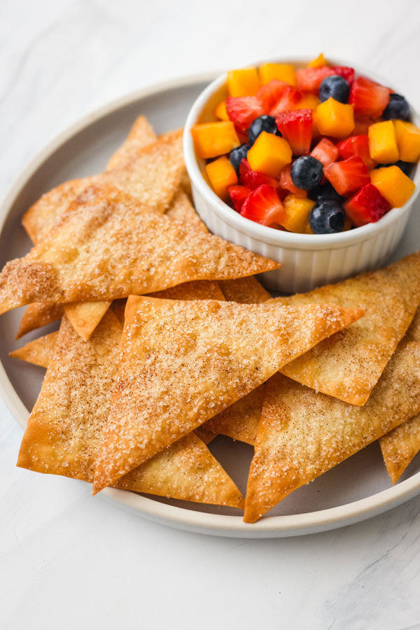 Crispy baked wonton chips piled on a blue plate.