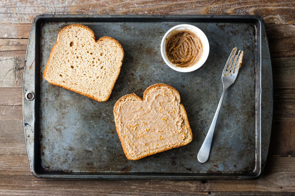 Two slices of bread with a small white bowl of cinnamon butter with a fork.