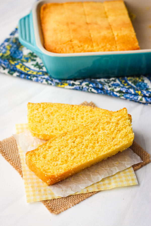 Sliced pieces of cornbread and cornbread in a blue baking dish. 