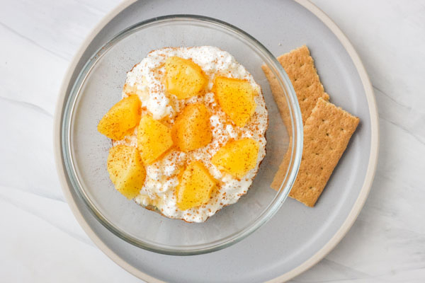 Cottage cheese parfait in a glass bowl with graham crackers.