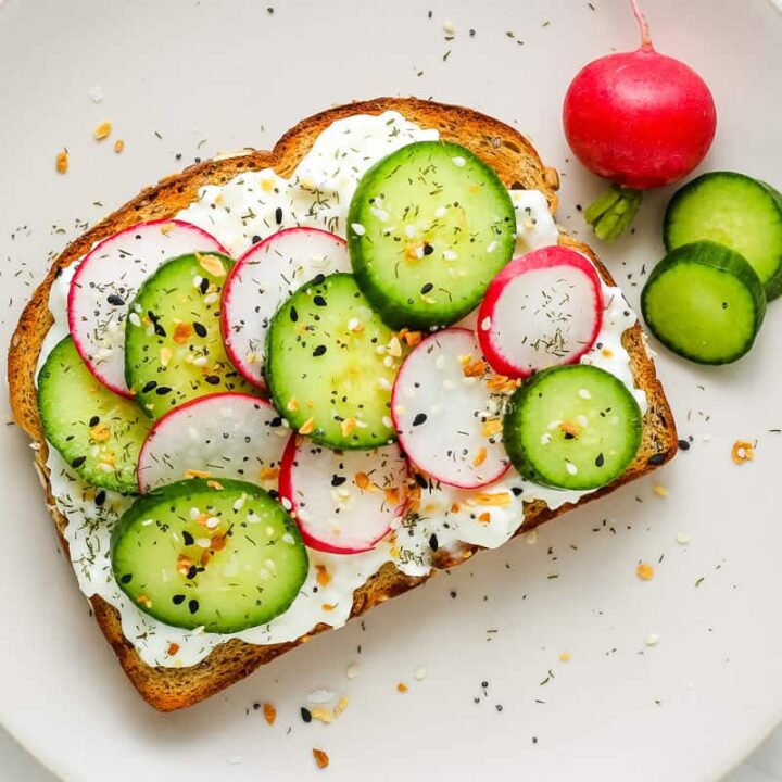 Toasted bread topped with cottages cheese, sliced cucumber, and radishes.