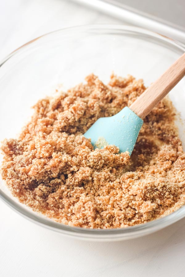 Buttery crumble mixture in a small glass bowl.