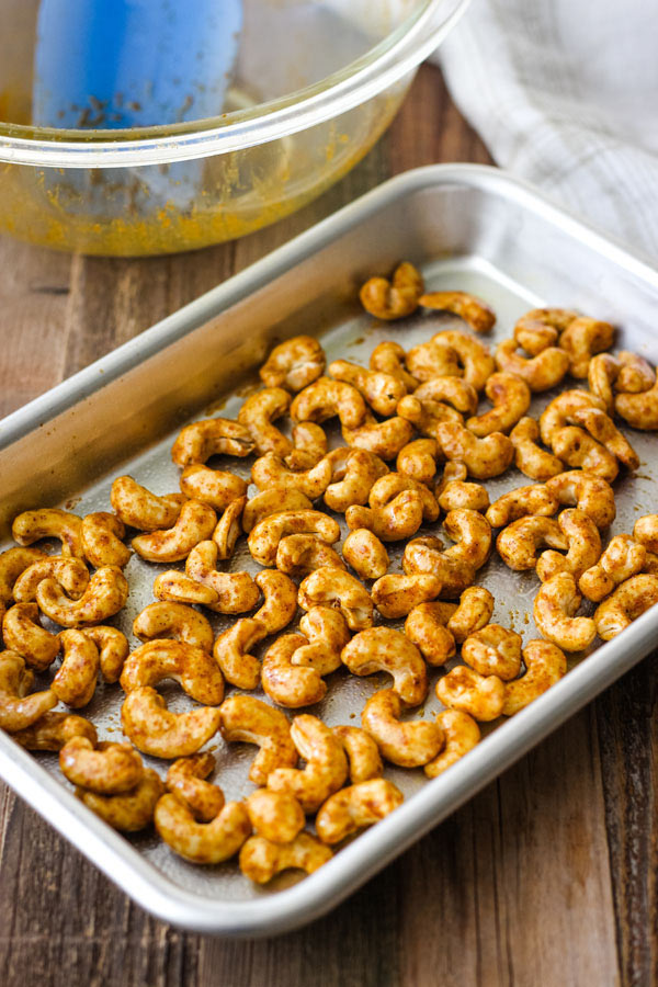 Coated cashews on a small baking sheet.