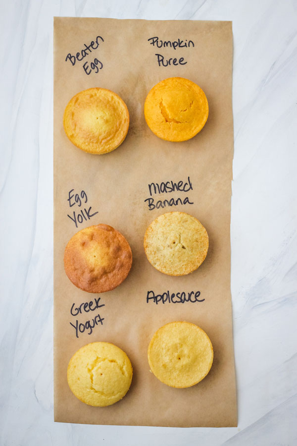 Six mini cakes on a piece of paper with the egg substitute used written next to each one.