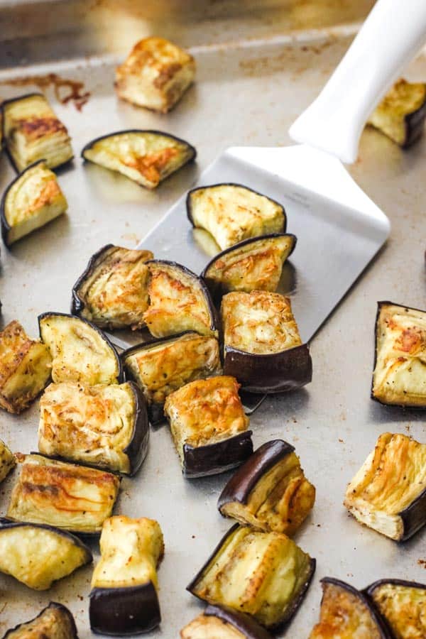 Roasted eggplant pieces on a sheet pan.