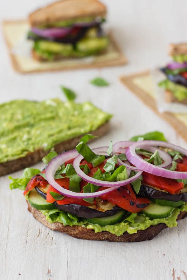 Cooked eggplant slices, fresh red onions, roasted peppers, cucumbers and mashed avocado layered on two slices of toasted bread