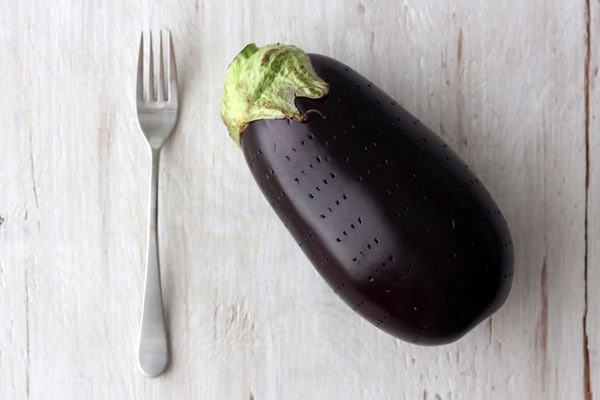 Whole eggplant stabbed all over with a fork.