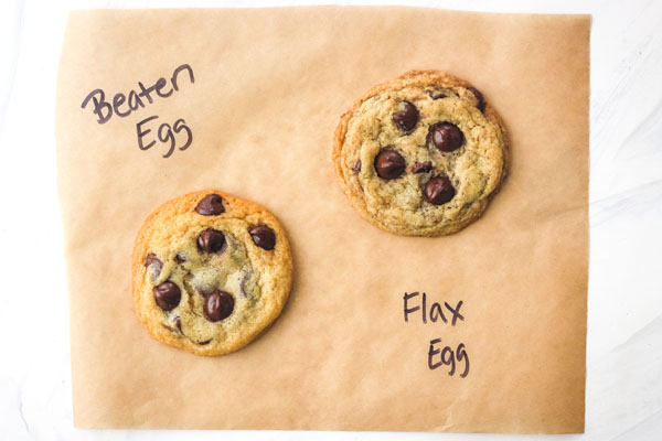 Two cookies on a piece of parchment labeled 'beaten egg' and 'flax egg'