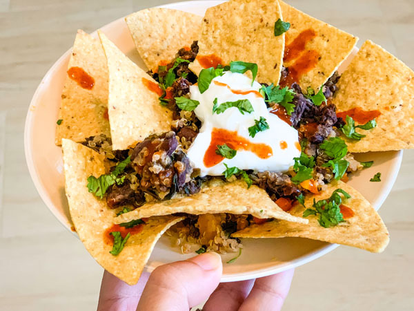Tortilla chips topped with a cooked black bean and quinoa frozen meal.