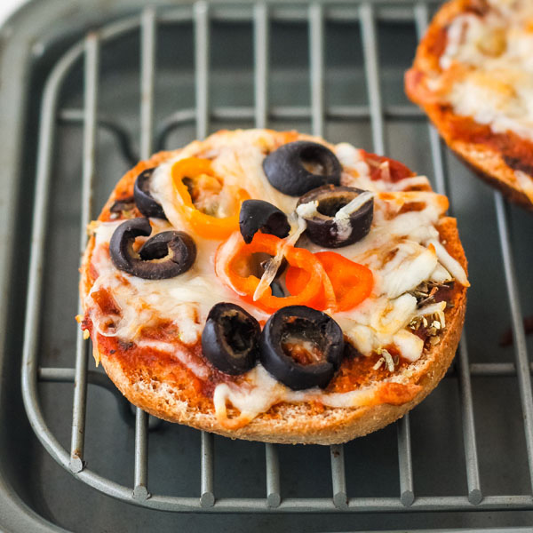 Cooked pizza bagel on a baking rack.