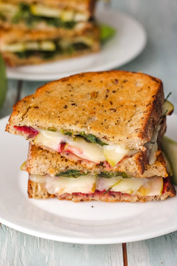 Two grilled cheese halves on a white plate.