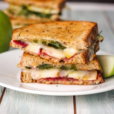 Grilled cheese slices stacked on a white plate.