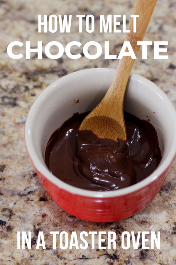 Red ramekin with melted chocolate chips and a wooden spoon.