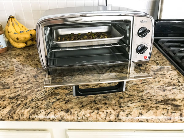 Pistachios toasting in a toaster oven.