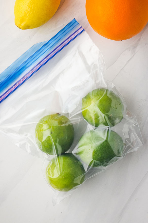 A freezer bag with four whole frozen limes.