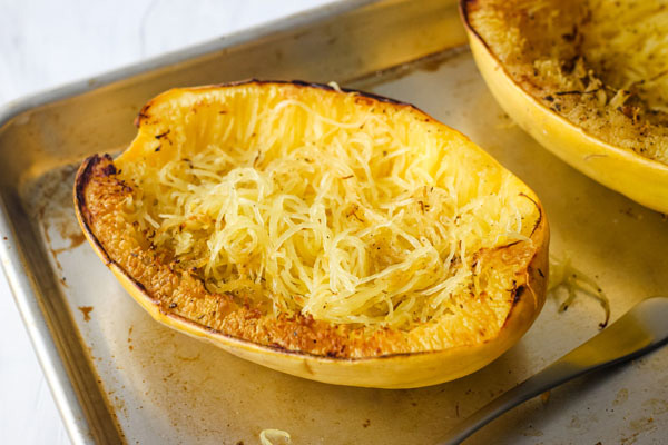 Roasted spaghetti squash on a baking sheet.