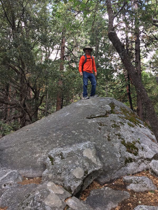 A man standing on a large bolder.