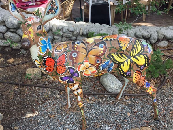 Deer statue painted with colorful butterflies.