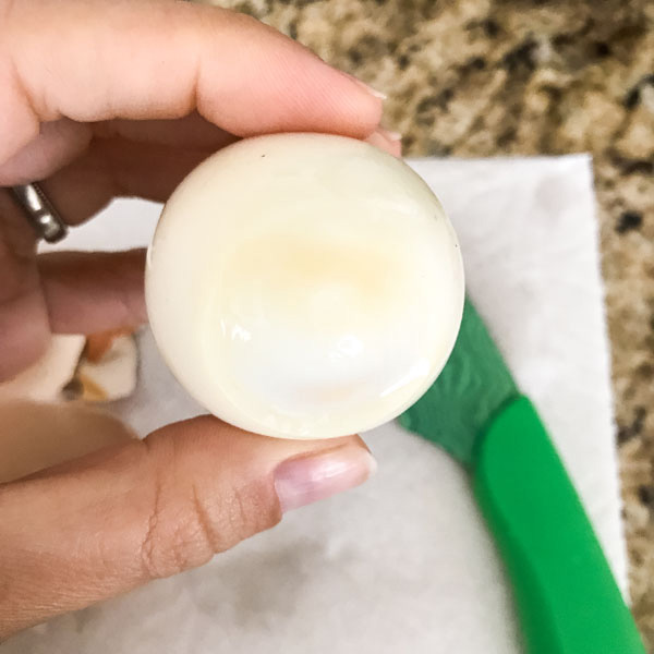 Bottom of a peeled egg with a light brown color.