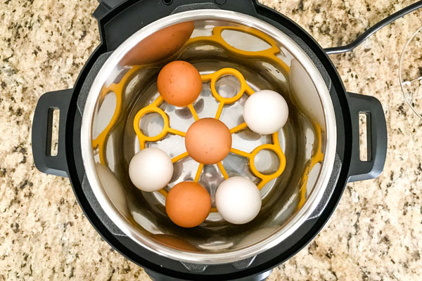 Eggs on a yellow silicone rack inside an instant pot mini.