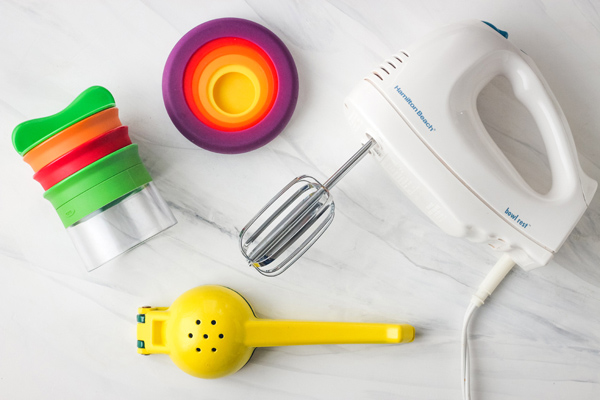 Hand mixer, handheld vegetable spiralizer, and yellow citrus juicer.