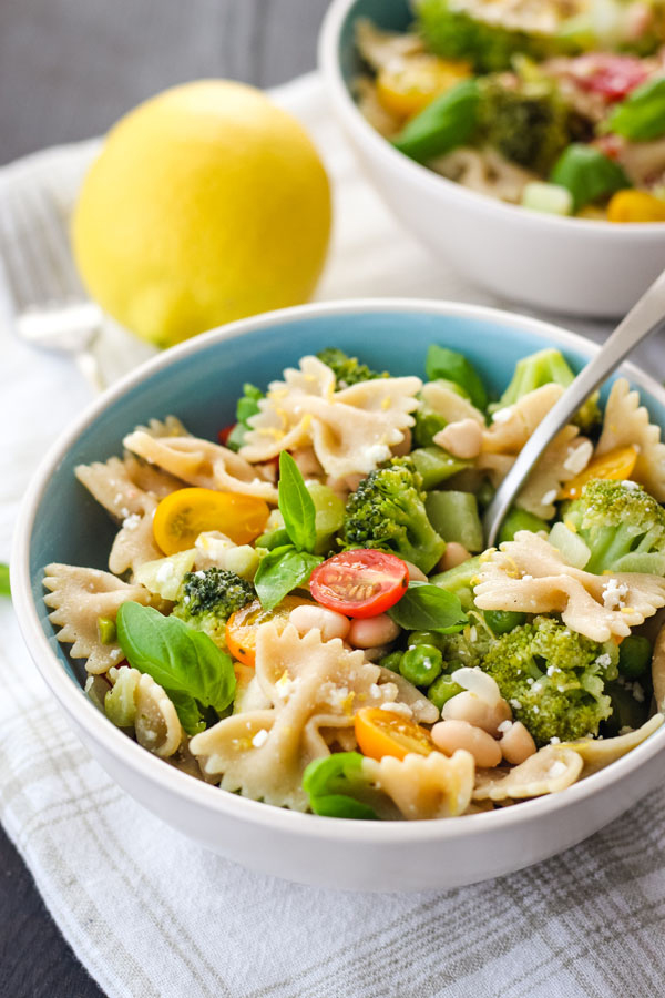 A blue and white bowl full of pasta with a fork sticking out of it.