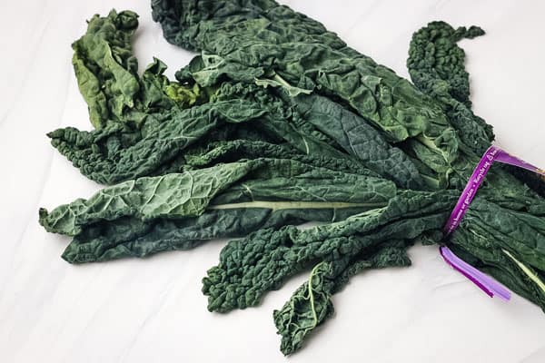 A bunch of limp kale on a counter.