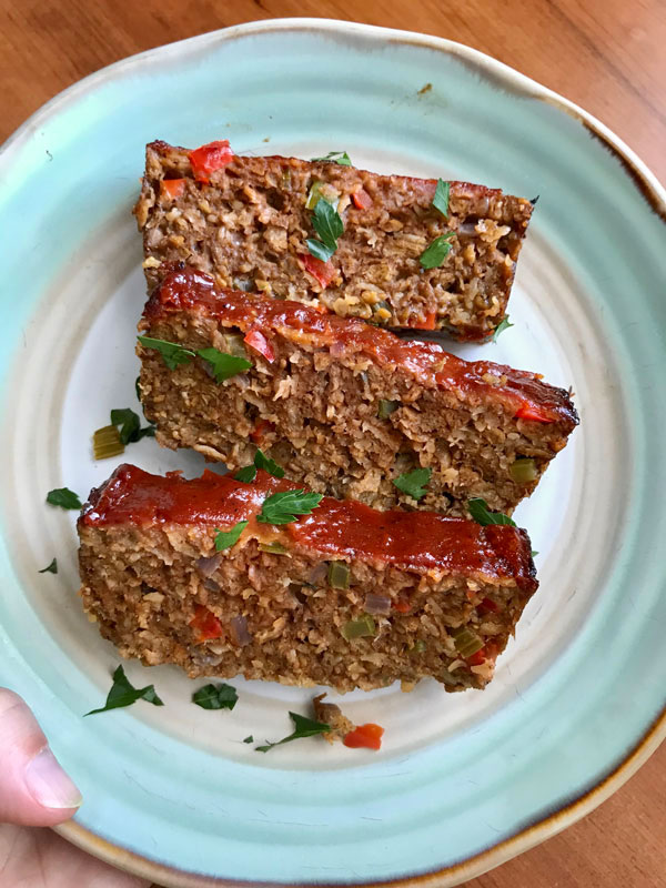 Three slices of meatloaf on a blue and white plate.