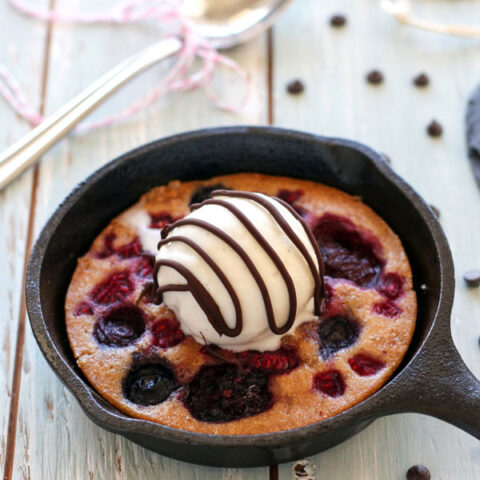 A table with chocolate chips surrounding a mini skillet cake.