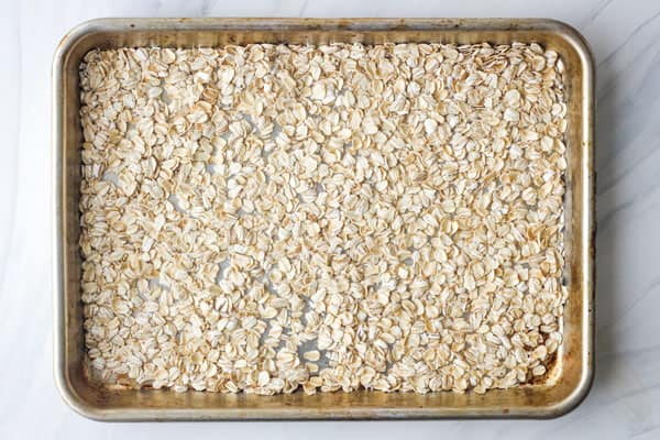 Rimmed sheet pan with raw oats.