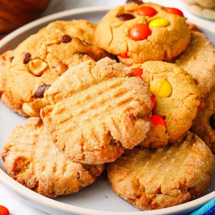 Variety of peanut butter cookies with candies and nuts arranged on a plate.