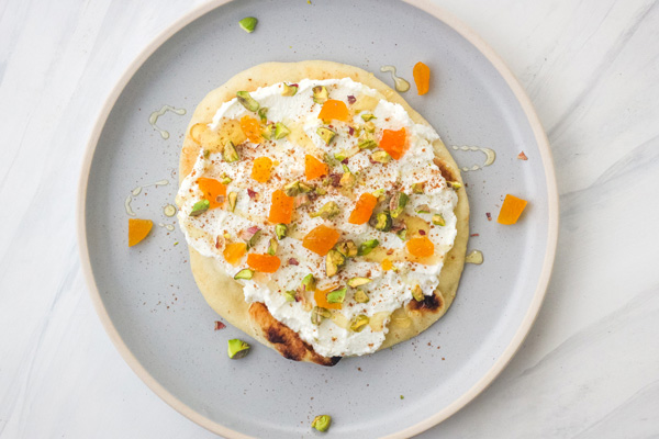 Mini naan topped with ricotta, dried apricot, and pistachio pieces.