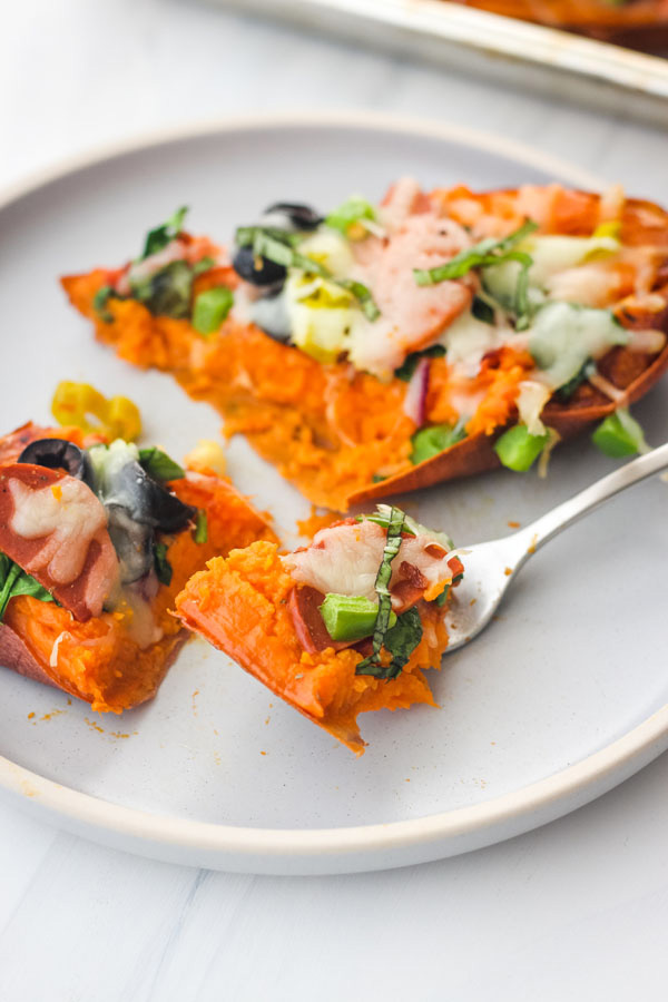 A blue plate with a sweet potato with a fork.