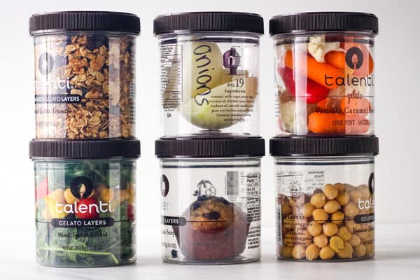 Talenti containers with granola, raw veggies, a muffin, salad, beans, and onion.