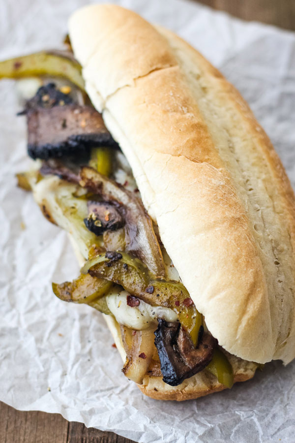 Closeup of hoagie stuffed with bell peppers, onions and cheese.