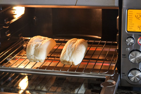 Rolls toasting on a cooking rack inside a countertop oven.