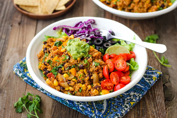 A white bowl with salsa quinoa on a blue napkin.