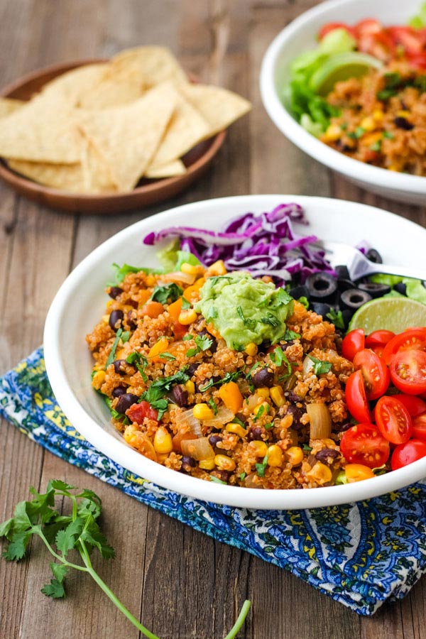 A white bowl with spicy quinoa on a wooden table.