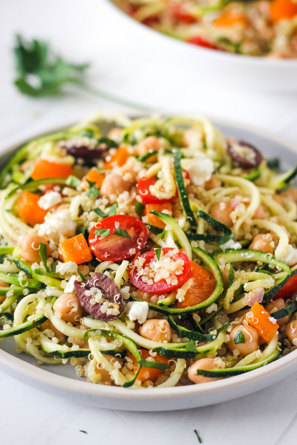 Close up of zucchini noodle salad on a blue plate.