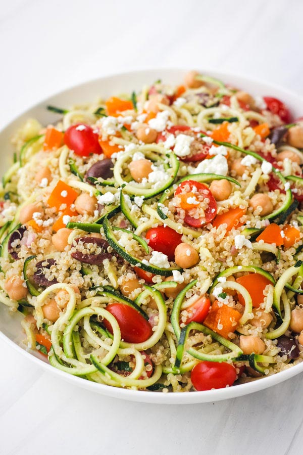 Zucchini Noodles Salad in a large white bowl on a white table.