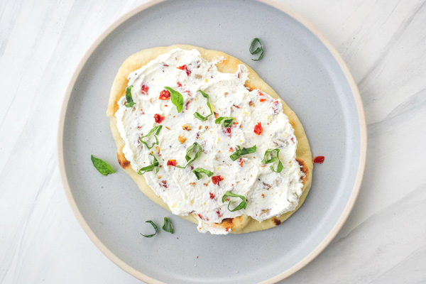 Blue plate with mini naan pizza.