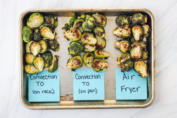 3 types of cooked Brussels sprouts on a sheet pan.