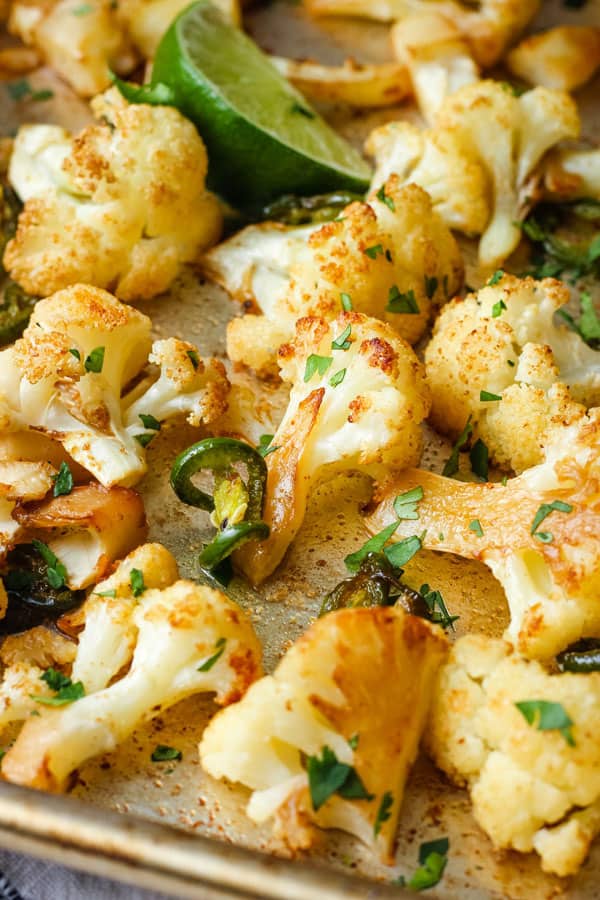 Close up of golden roasted cauliflower florets on a sheet pan.