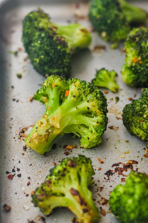 Cooked broccoli on a metal sheet pan.